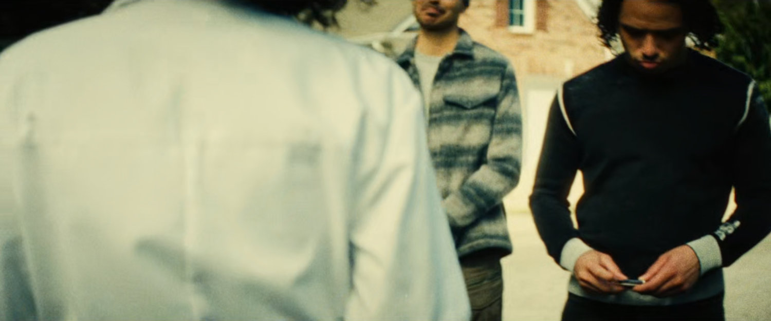 The Hood gives Clown his business car while John looks on.