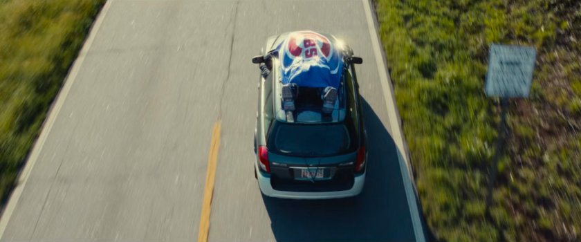 Joe's car with the Ironheart armor strapped to the roof driving on an Illinois road.
