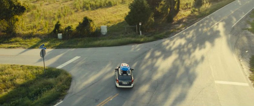 Joe's car with the Ironheart armor strapped to the roof driving on an Illinois road.