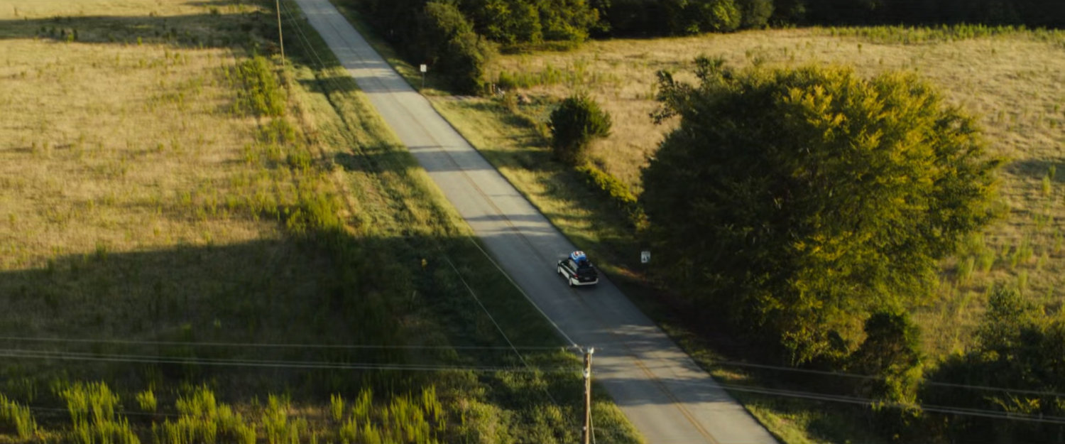 Joe's car with the Ironheart armor strapped to the roof driving on an Illinois road.