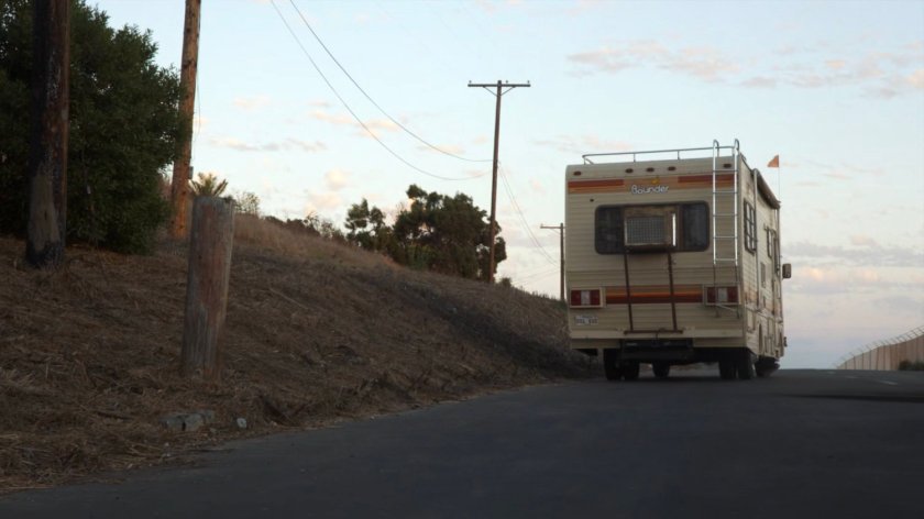 A motor home driving away from a military base.