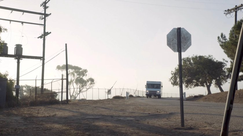 Repair truck driving towards military base.