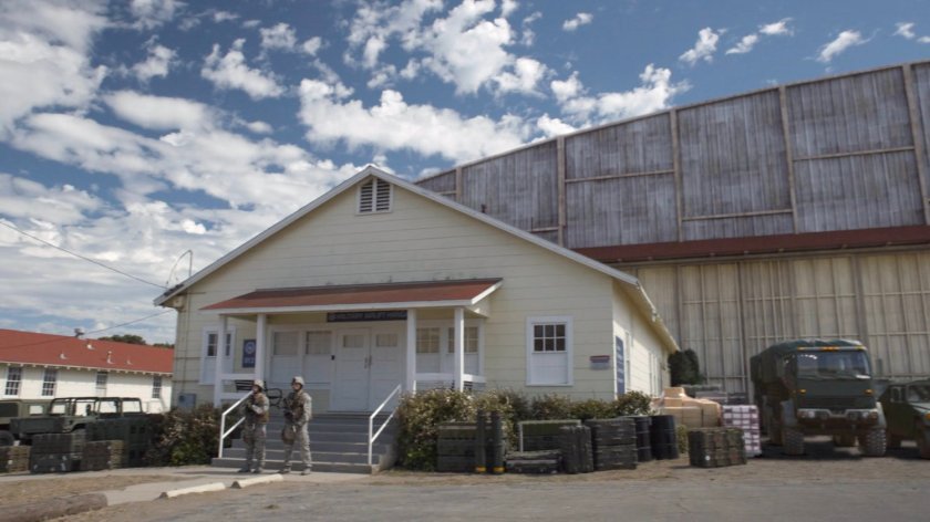 Two guards outside military airlift hangar.