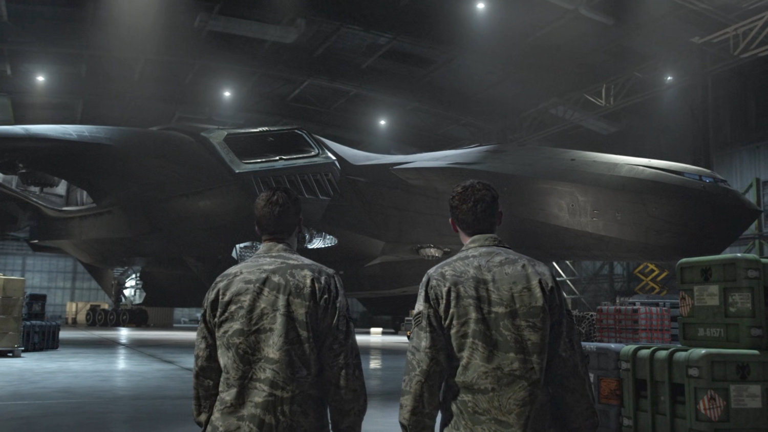 Fitz and Hunter in a military warehouse/hangar looking at Zephyr One.