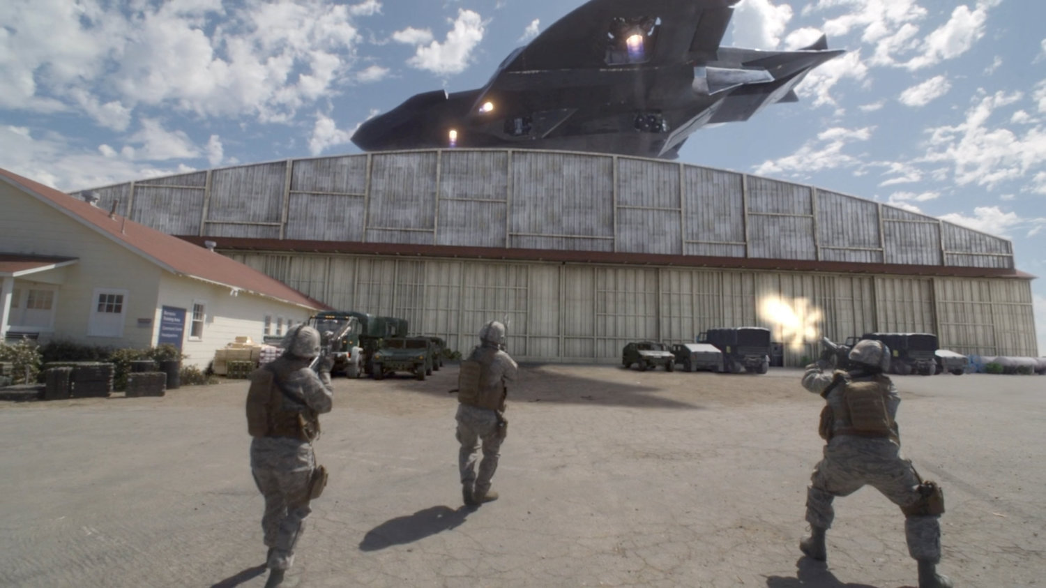 Soldiers outside a military hangar as Zephyr One flies away.