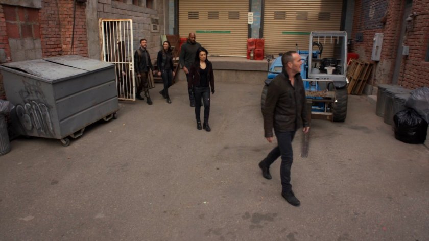 Coulson and the Agents emerging from a gate into an alley in River's End.