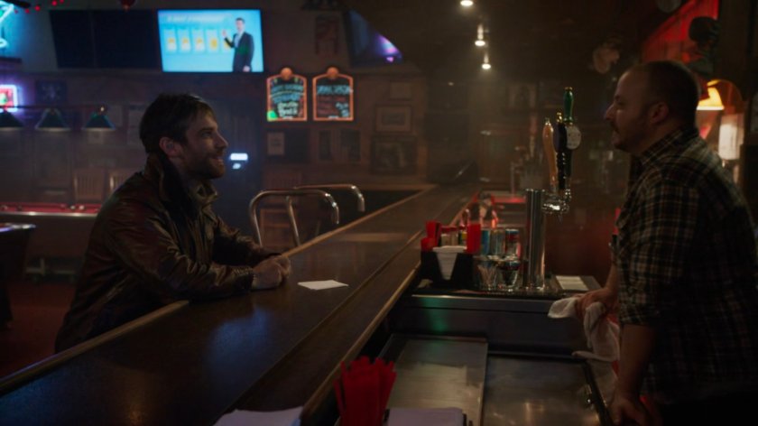 Deke and a bartender in a bar in River's End.