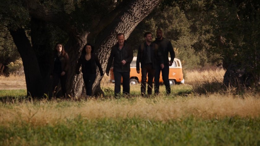 The agents walking across a field outside River's End.