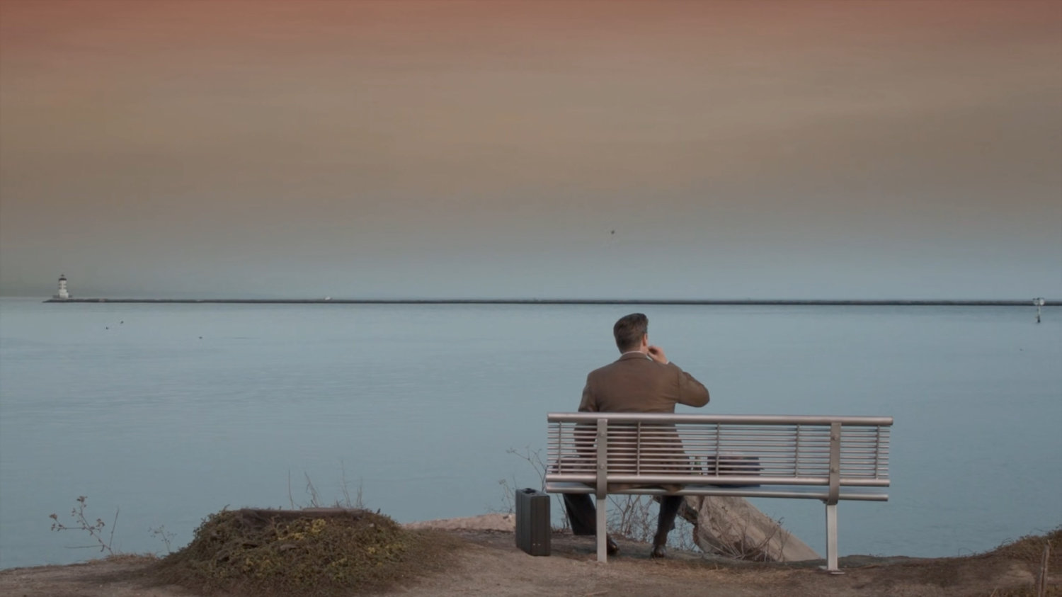 Joseph Getty on a bench overlooking a harbor.