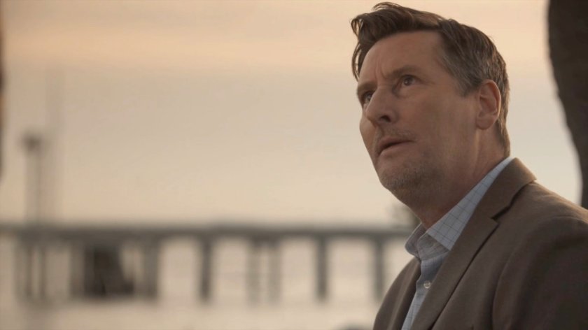 Joseph Getty on a bench overlooking a harbor.