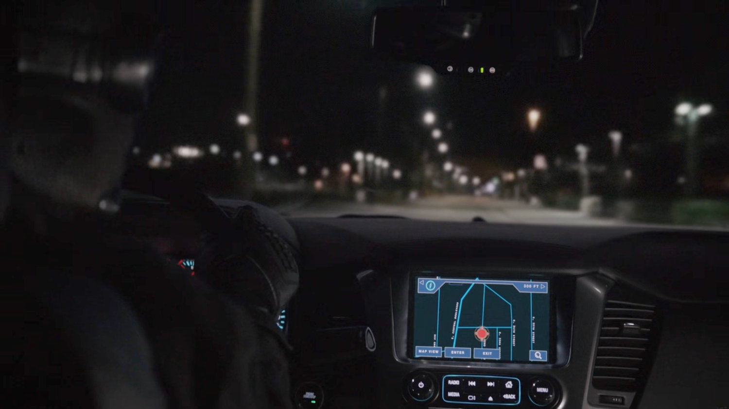 View of car dashboard and road at night.