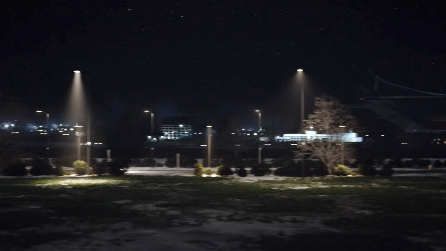 Car driving along road at night.