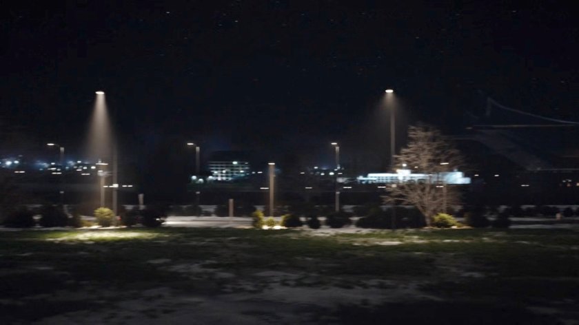 Car driving along road at night.