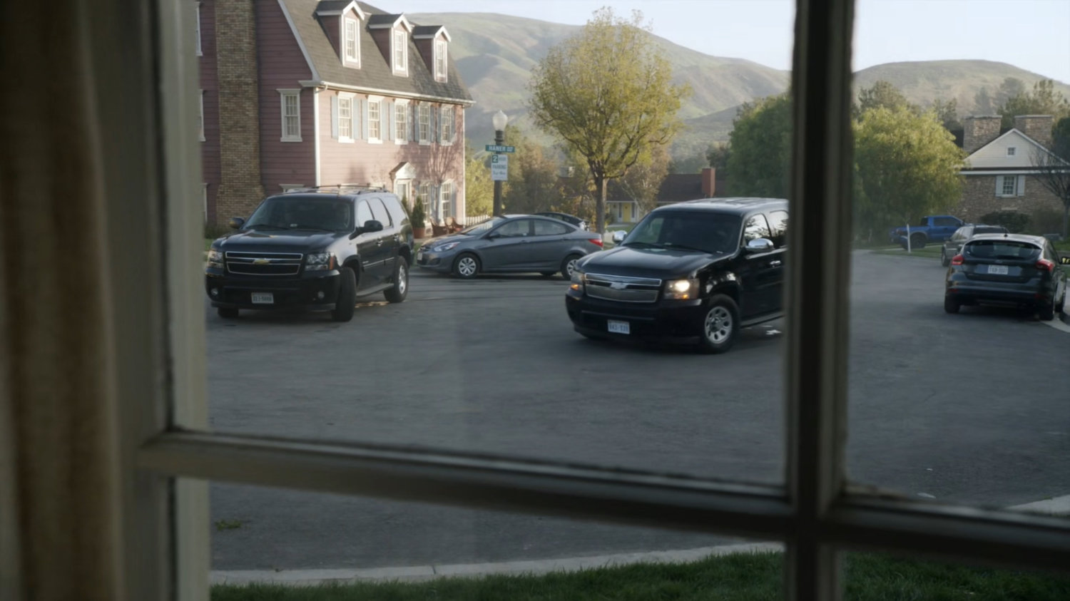 SHIELD SUVs pull up outside the Talbot house.