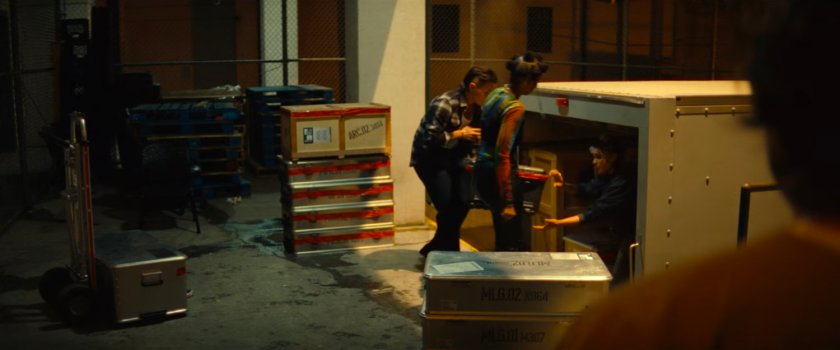 Jeri, Roz, and Clown loading Joe's gear into a van at the loading dock of Cook County Jail.