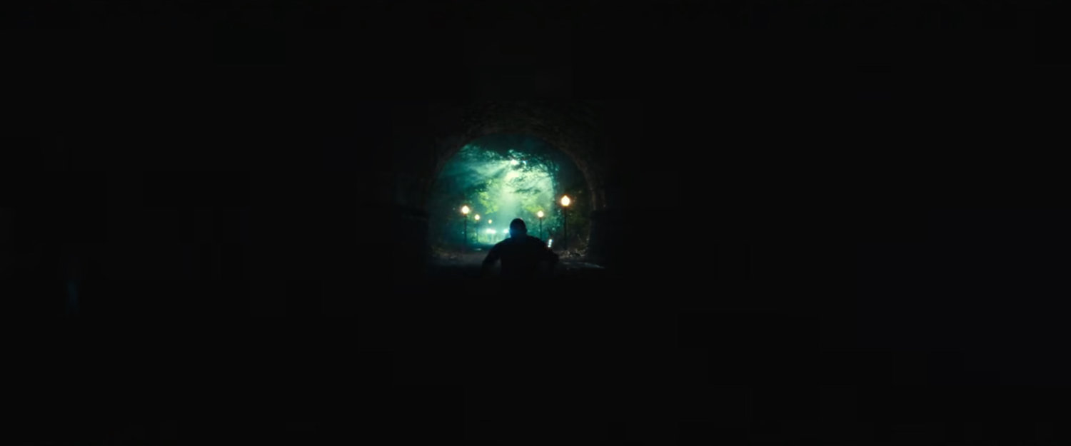 Parker runs through an eerie tunnel outside the fancy mansion.