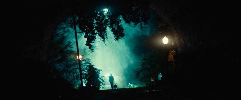 Guard with dog heading toward an eerie tunnel outside the fancy mansion.