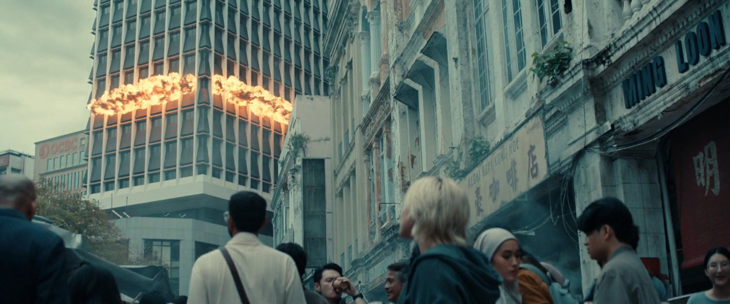 Yelena watching building explosion from a street in Kuala Lumpur.