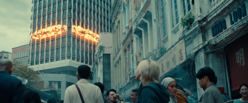 Yelena watching building explosion from a street in Kuala Lumpur.