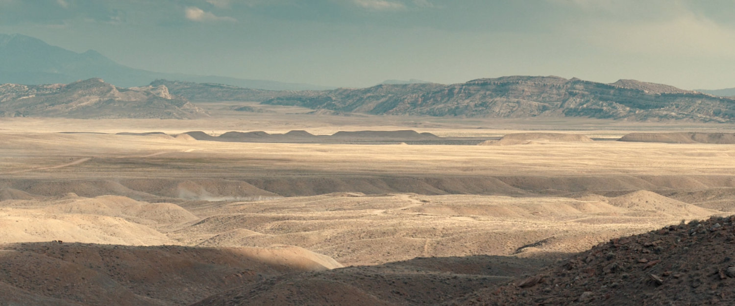 A limo approaching through the desert of Utah.