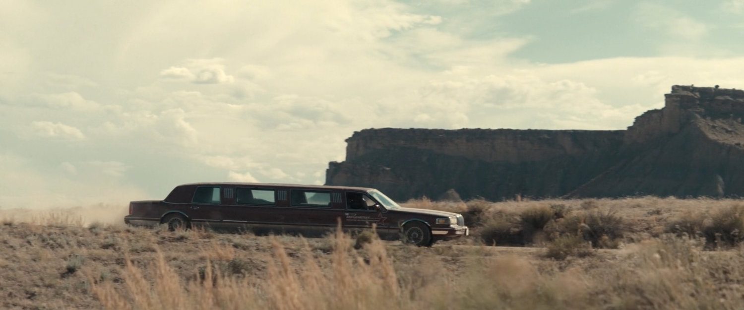 A limo approaching through the desert of Utah.
