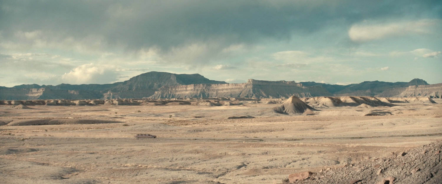 A limo driving across the desert of Utah.