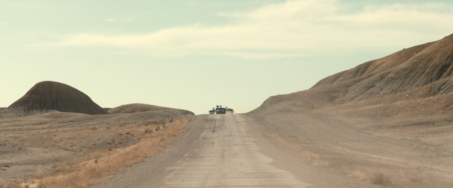 Three APCs driving across the desert of Utah.
