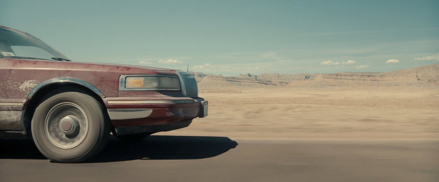 A limo driving across the desert of Utah.
