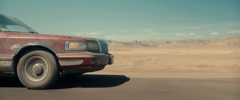 A limo driving across the desert of Utah.