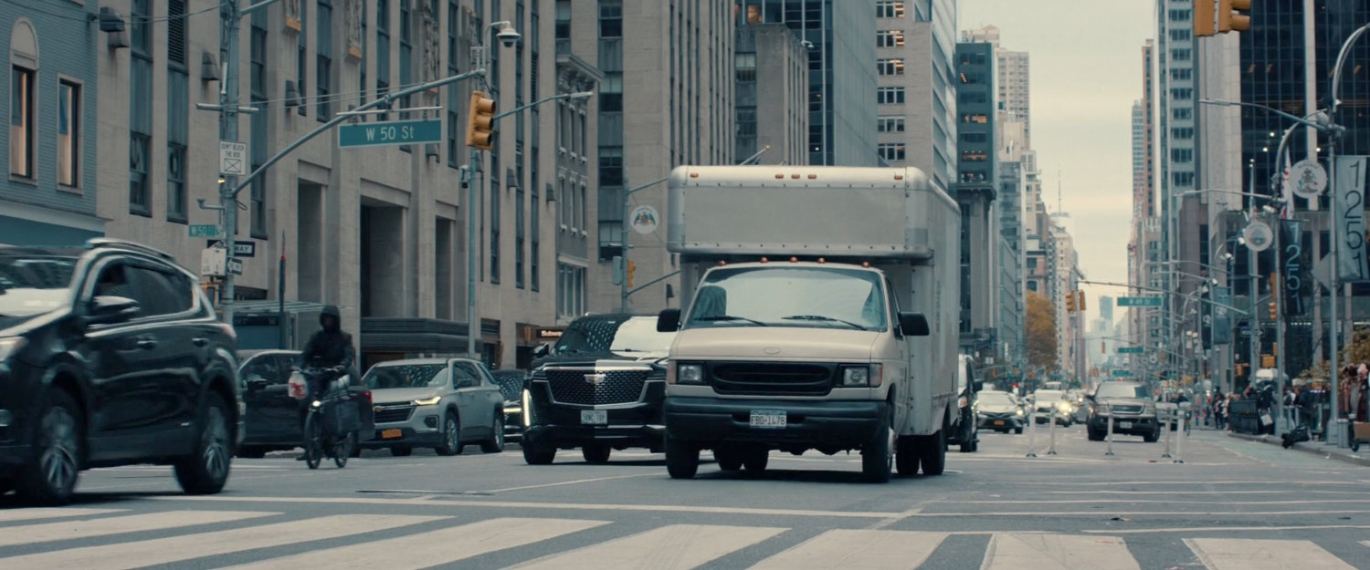 A box truck driving past W. 50th Street in New York City.