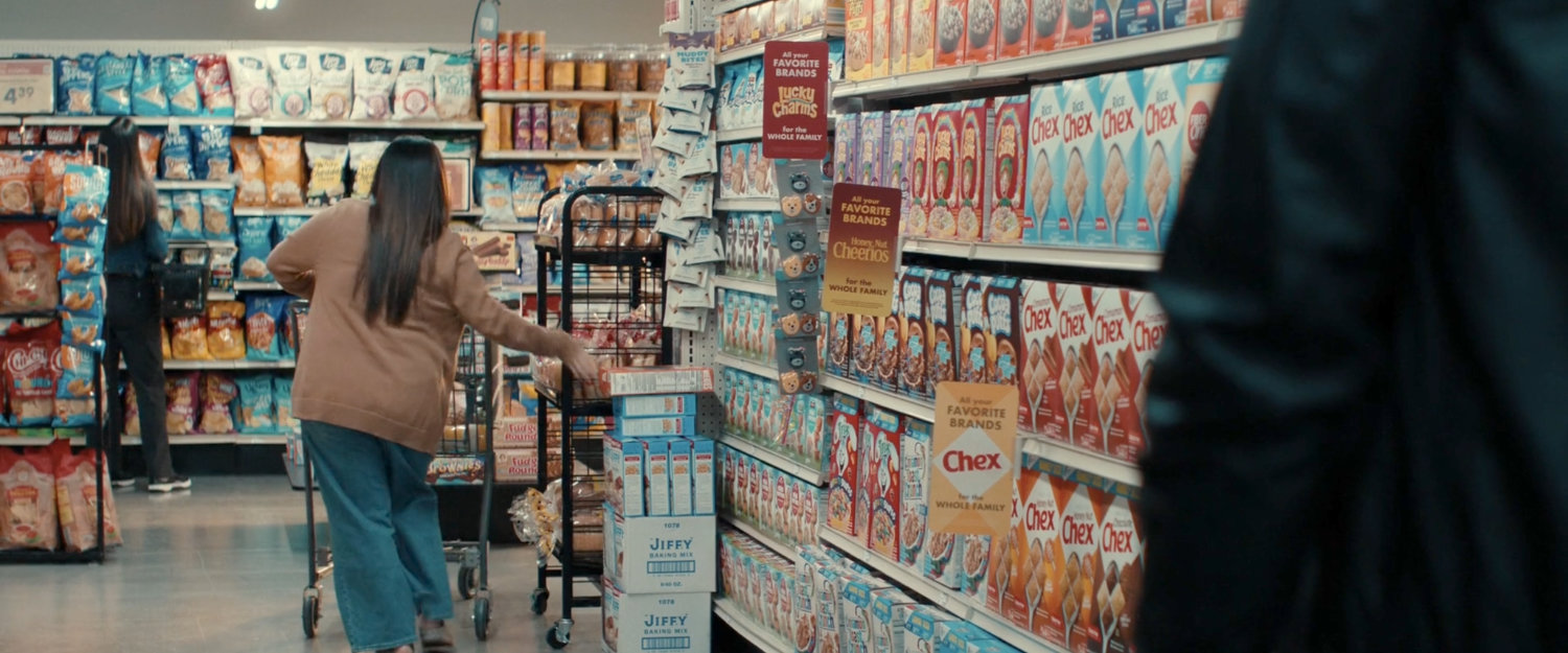 Alexei and a woman in the cereal aisle of a grocery store.