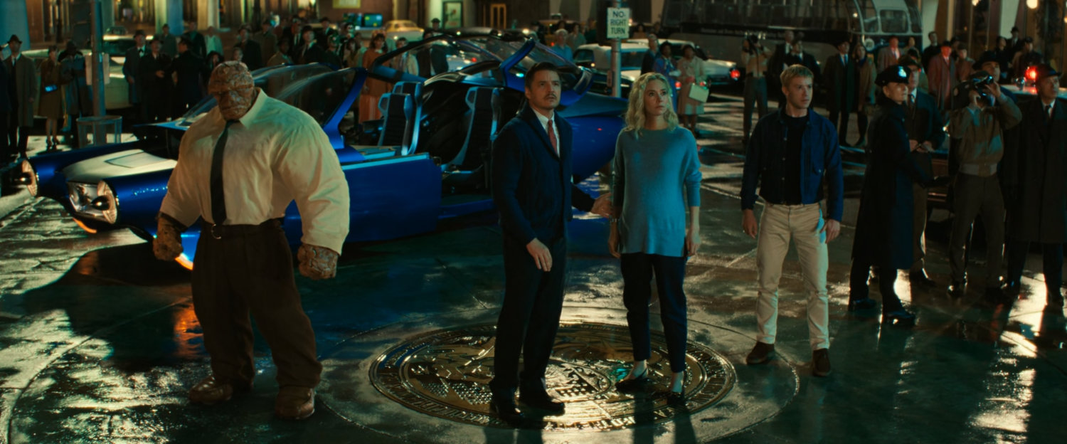 Ben, Reed, Sue and Johnny stand in the middle of Times Square at night.