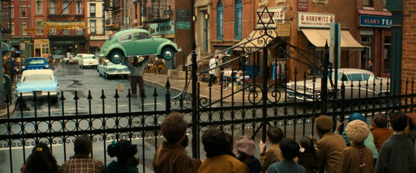 Ben, showing off to school children, by lifting a car above his head on Yancy Street.