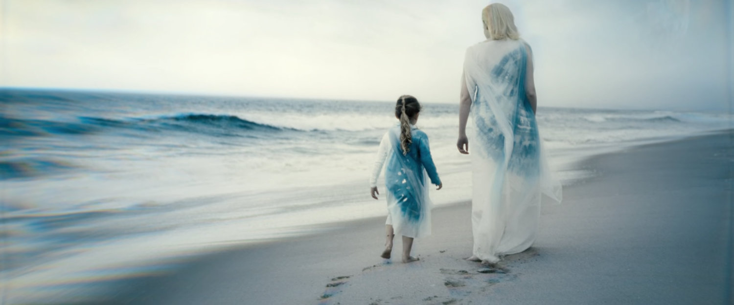 Flashback of Shalla-Bal on Zenn La with her daughter, walking on the beach.