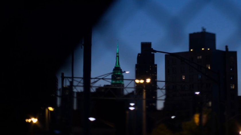 The Empire State Building at dusk as seen through other buildings.