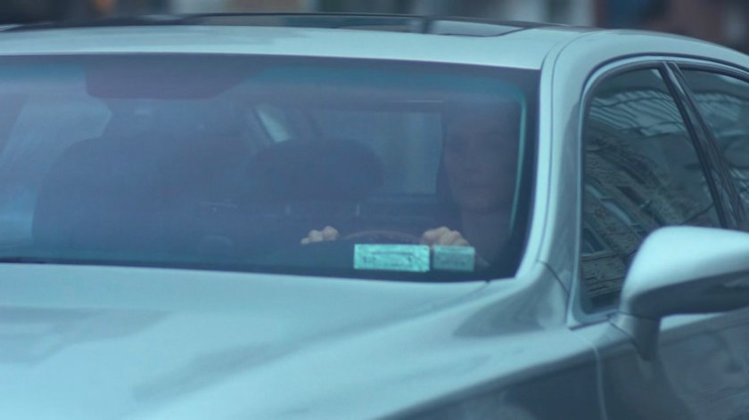 Jeri sitting in her car at a stoplight.