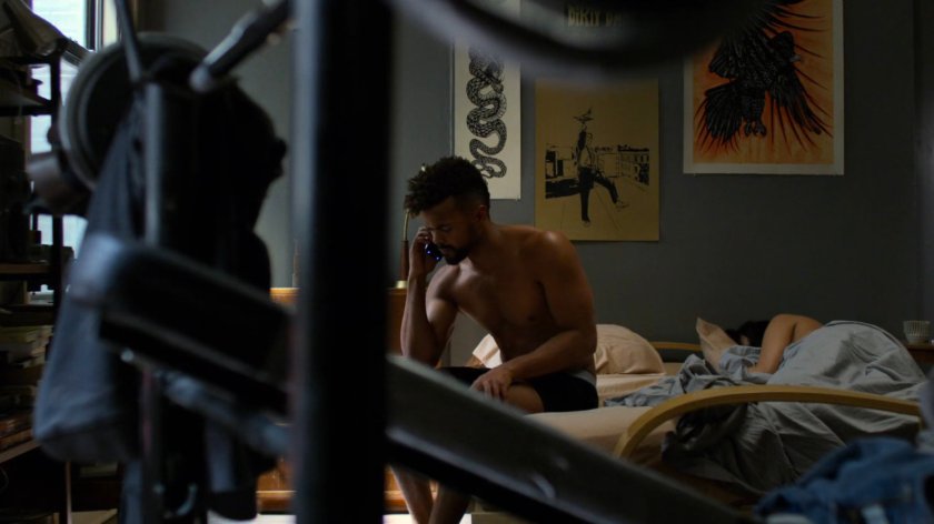 Malcolm on the phone while sitting on his bed.