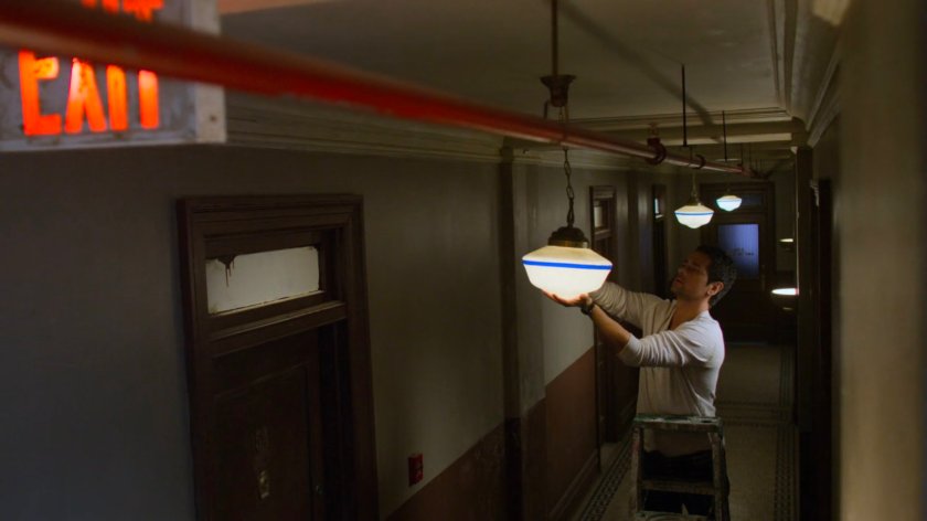 Oscar changing the lightbulb in the hallway out Alias Investigations
