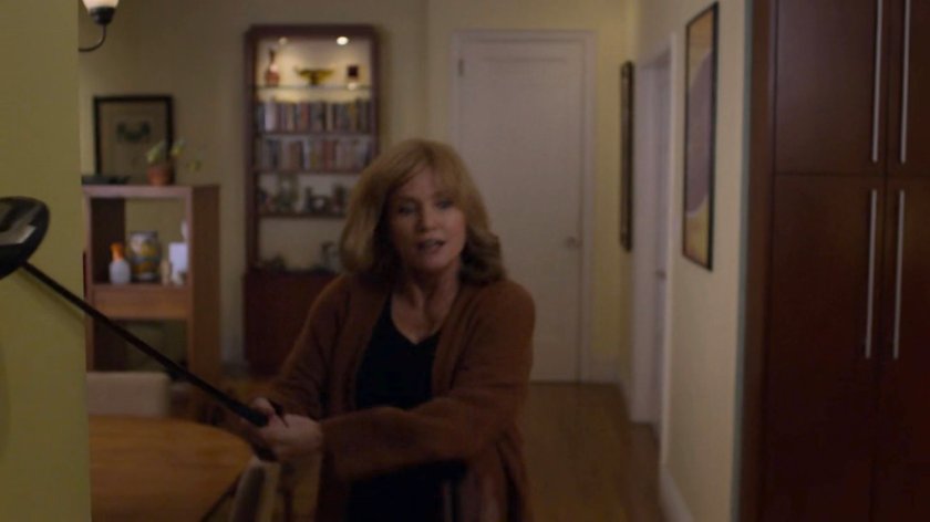 Dorothy Walker swinging a golf club at an intruder in her apartment.