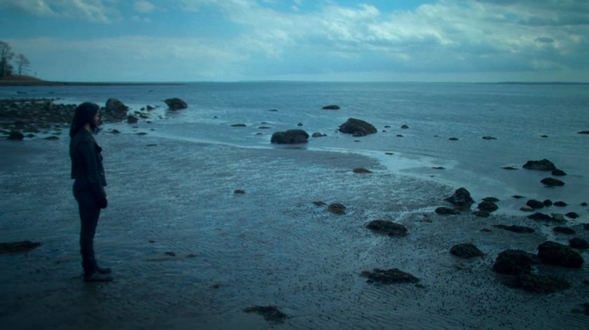 Jessica standing on a rocky beach.