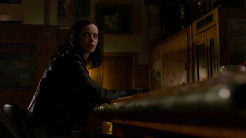 Jessica sitting in a dark bar.