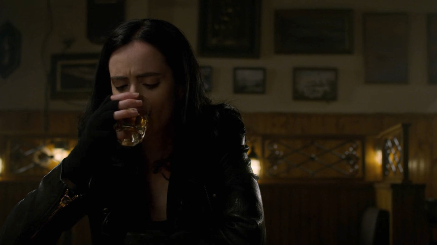 Jessica sitting in a dark bar.