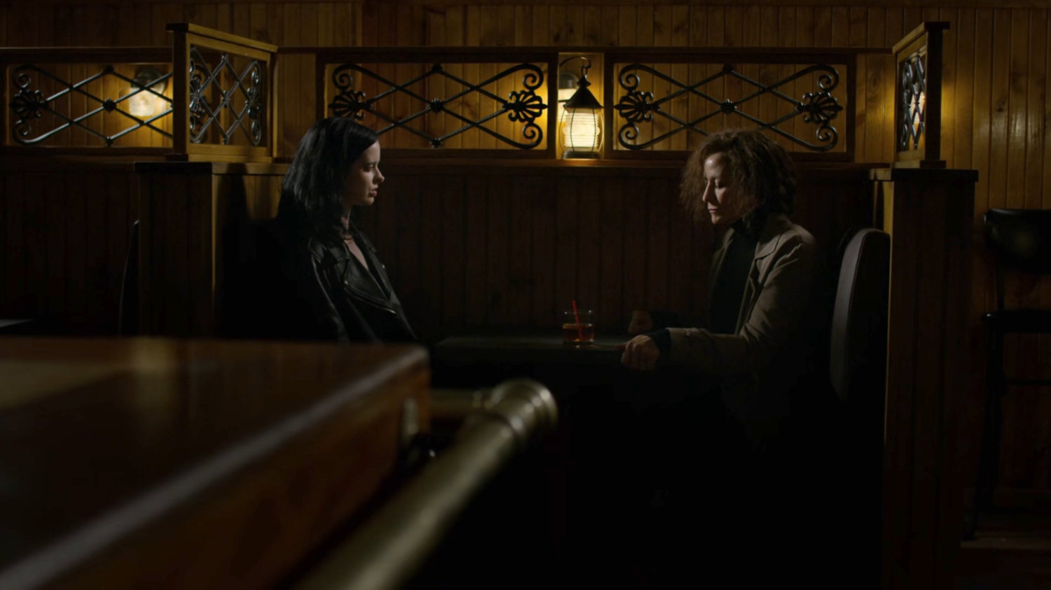 Jessica sitting in a dark bar with "Leslie Hansen" (aka Alisa).