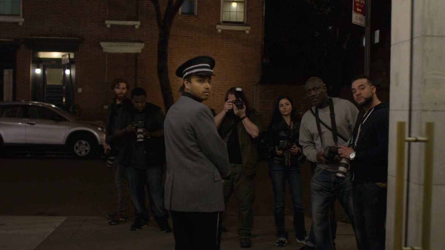 Paparazzi gather outside Trish's apartment building.