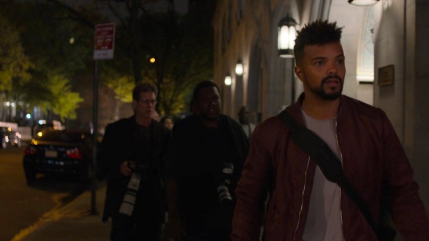 Paparazzi follow Malcolm outside Trish's apartment building.