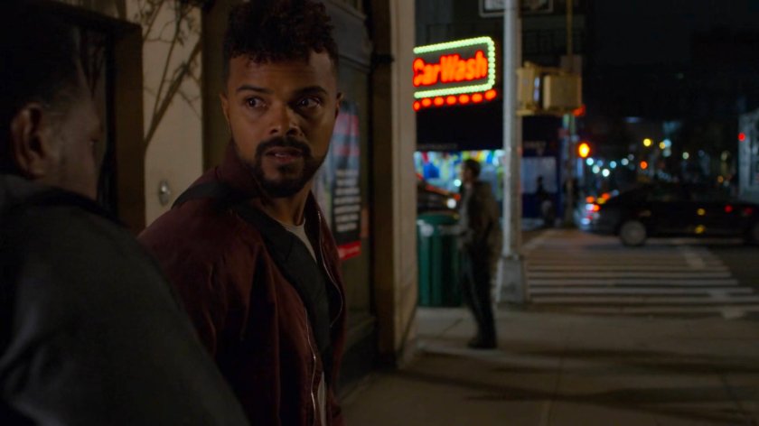 Malcolm talks to a paparazzo outside Trish's apartment building.