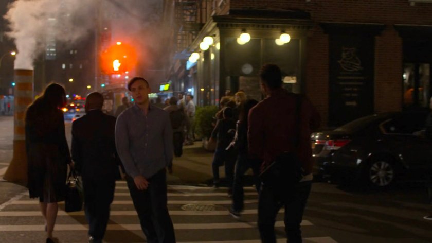 Malcolm crossing the street outside Trish's apartment building.