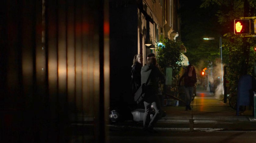 Jessica in pursuit on the sidewalk outside a dark bar.