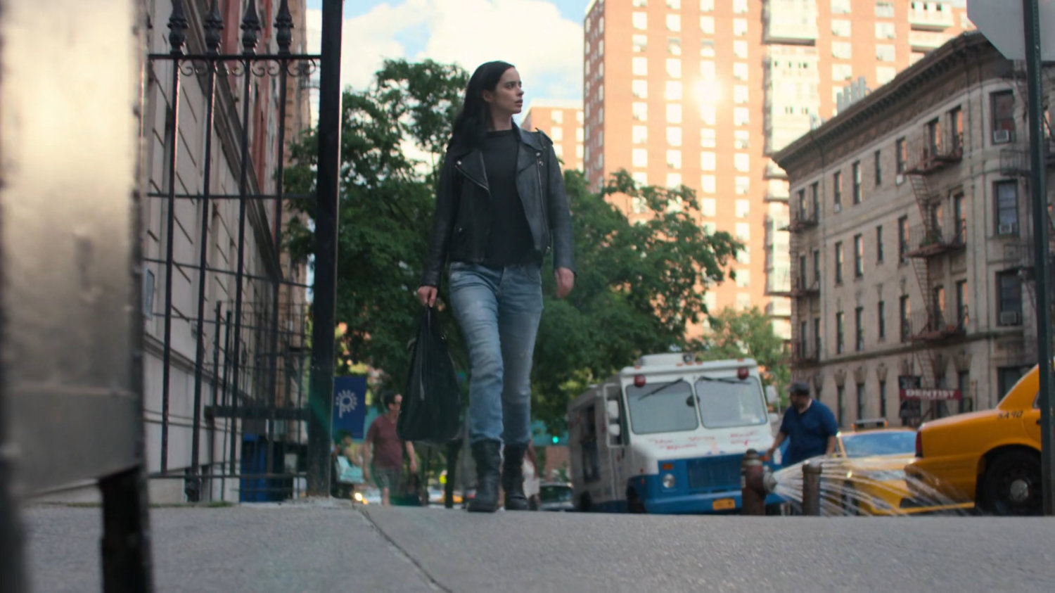 Jessica walks along the sidewalk back to her apartment building.