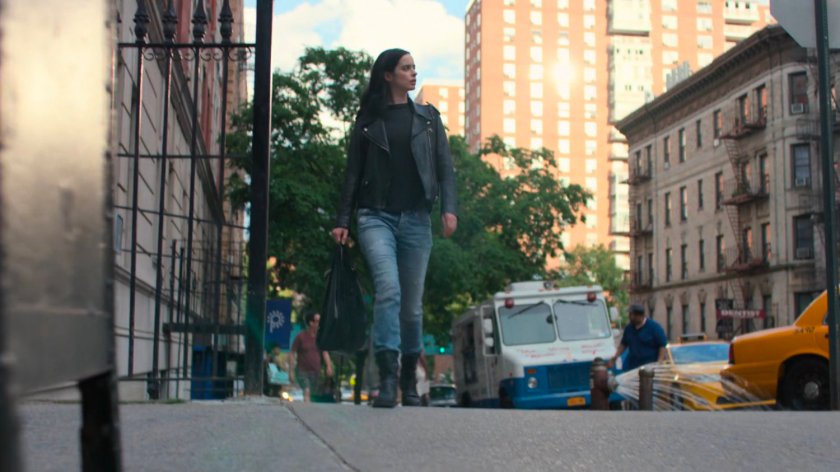 Jessica walks along the sidewalk back to her apartment building.